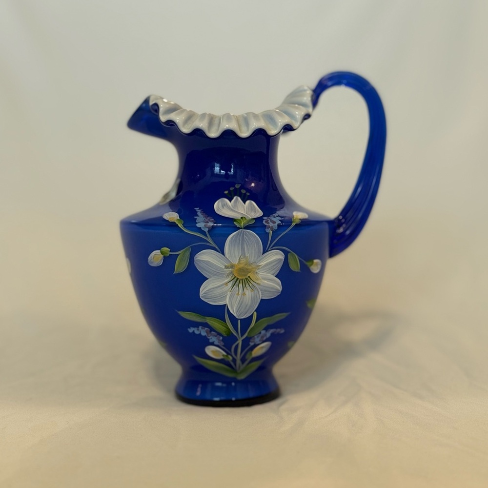 FENTON GLASS 1999 COBALT OVERLAY PITCHER WITH HANDPAINTED WHITE FLORAL